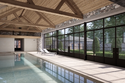 Pool house integrated between existing stone outbuildings and main house in Guernsey.